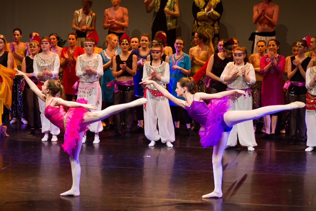 Dancers in colourful tutus in arabesque on stage